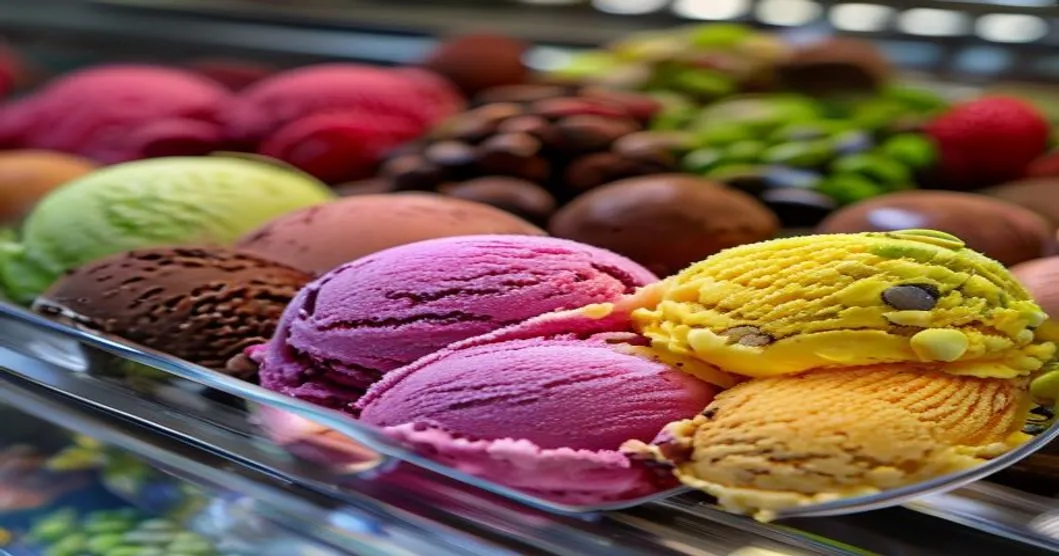 Colorful gelato flavors displayed in a gelato case, chocolate and fruit varieties