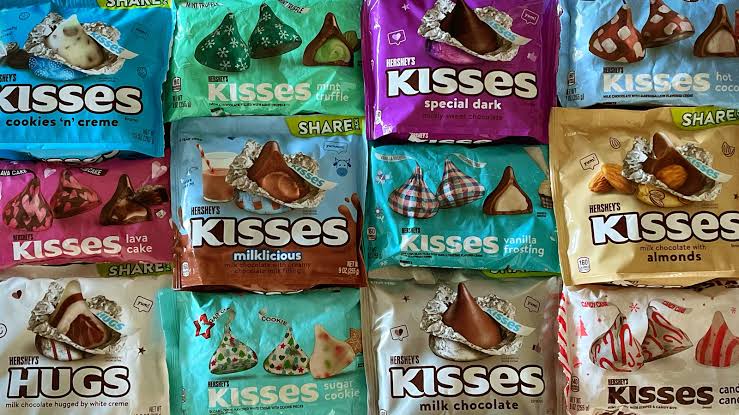 Assorted Hershey's Kisses flavors in colorful foils and unwrapped.