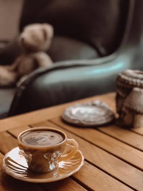 Raw sugar packet beside a cup of coffee